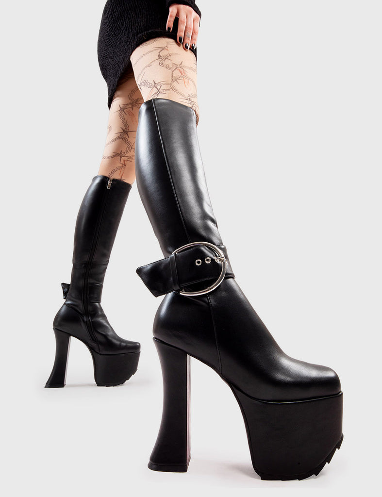 Not Your Basic Boots! Kick Start Platform Knee High Boots in Black faux leather. These platform boots feature a minimalist design, with a large Silver buckle around the ankle on our platform sole and curved heel. Made with eco-friendly materials and 100% cruelty-free, these platform boots are as ethical as they are Trendy. - Platform Height - Heel Height - Black zip - Large Silver buckle and eyelets - Curved Heel - Platform Sole - 100% vegan SKU: LMF 2996 - BlackPU