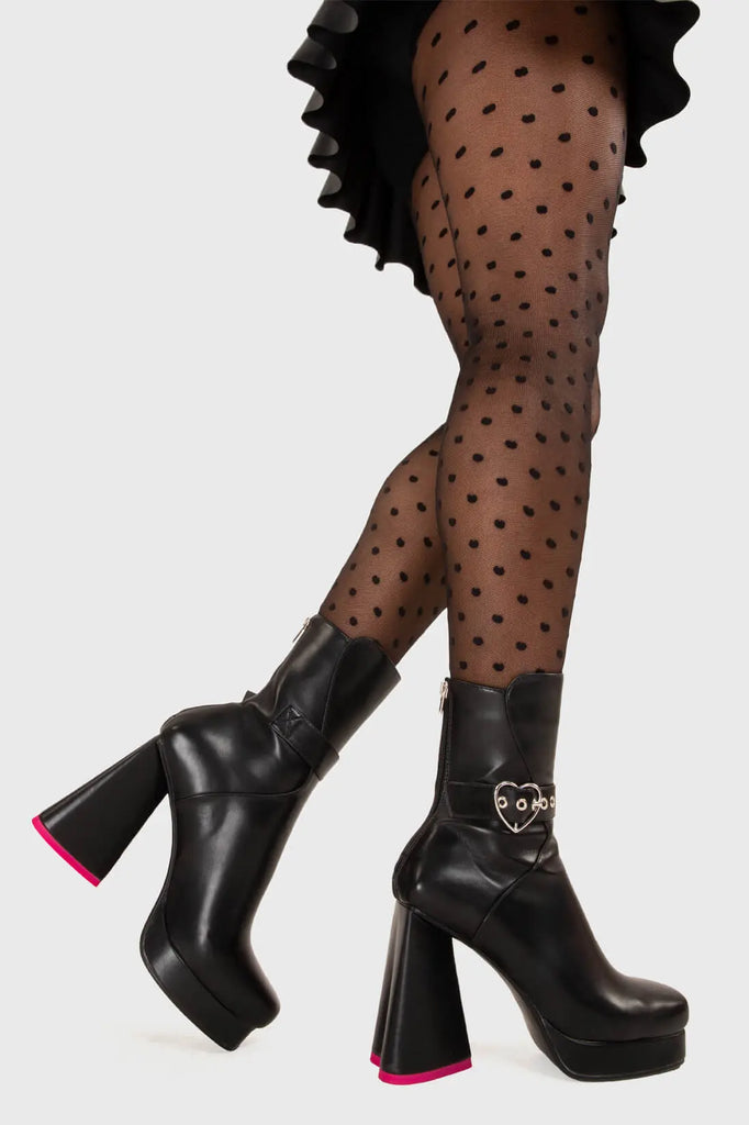 HEART TO HEART All Yours Platform Ankle Boots in Black fitted faux leather. These platform boots feature a silver heart buckle and a heart shaped heel, keeping it nice and classy. Made with eco-friendly materials and 100% cruelty-free, these platform boots are as ethical as they are chic. - Platform Height - Ankle length - Silver heart buckle - Pink sole - heart shaped heel - High Heel - 100% vegan SKU: LMF 3367 - BlackStretchPU