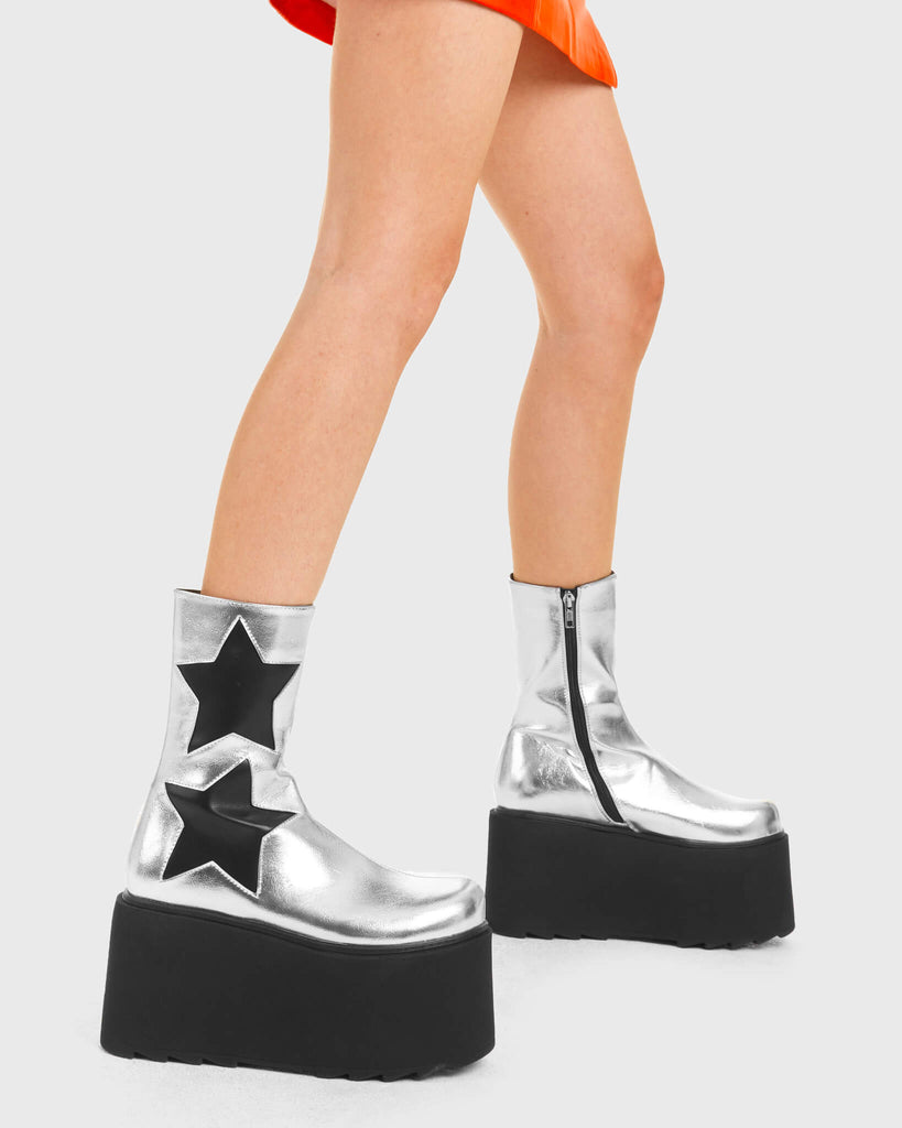 ELEVATED Big Shot Chunky Platform Ankle Boots in Silver Faux Leather. These vegan western Boots feature a black star design and a shark teeth grip sole, very edgy. Made with eco-friendly materials and 100% cruelty-free, these boots are as ethical as they are Chic! - Chunky Platform - Ankle length - Shark teeth grip - Black Stars - Rounded toe - 100% vegan SKU: LMF 3745 - SilverPU/BlackStar