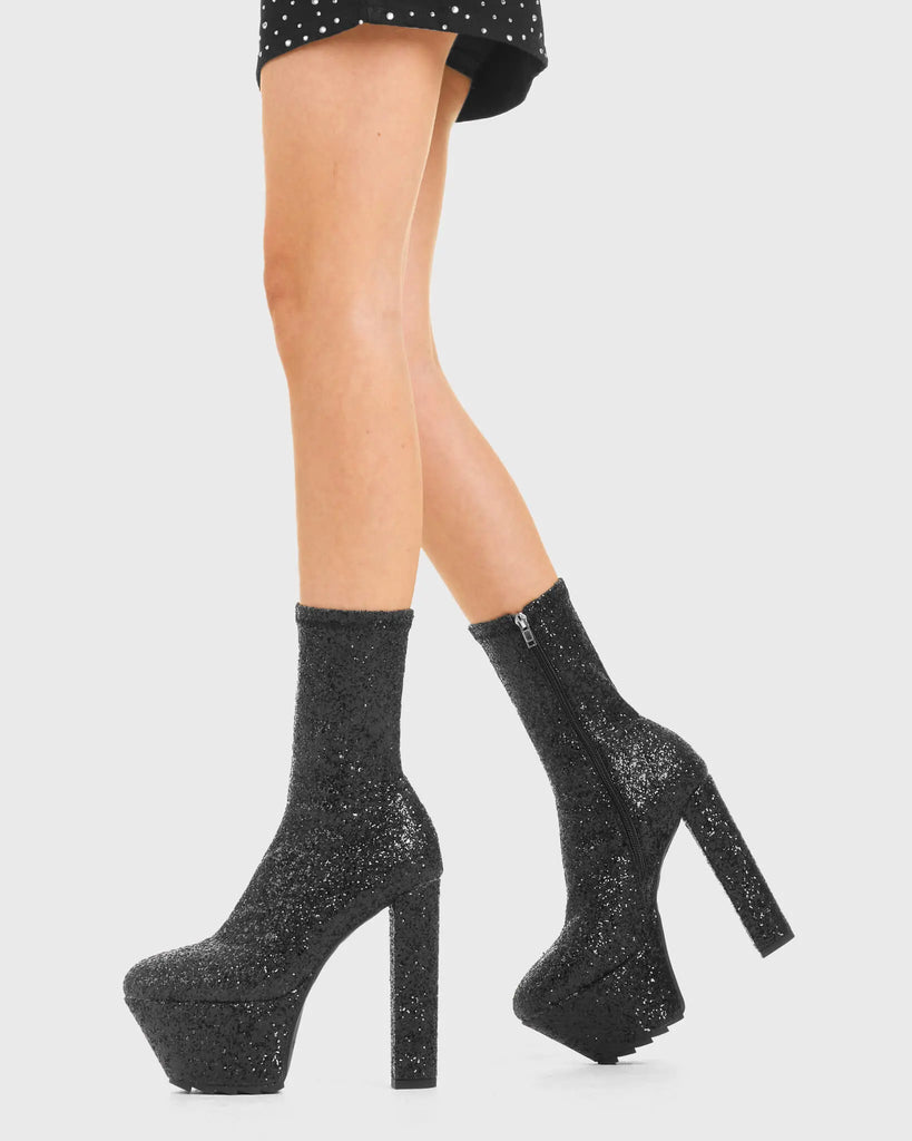 TIME TO PARTY Bling Platform Ankle Boots in Black Glitter. These vegan western Boots feature a glittery look, perfect for a night out. Made with eco-friendly materials and 100% cruelty-free, these boots are as ethical as they are Eye-Catching! - Platformed high heel - Calf length - Black Glitter - Shark teeth Grip - Rounded toe - 100% vegan SKU: LMF 3819 - BlackGlitter
