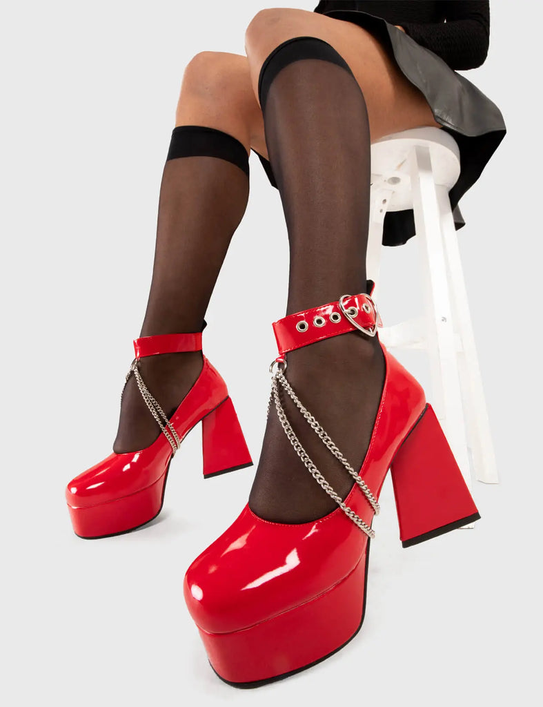 UNSTOPPABLE Break Up Platform Heels in Red patent. These platform boots feature a silver heart buckle with an adjustable strap, and chains, keeping it nice and classy. Made with eco-friendly materials and 100% cruelty-free, these platform boots are as ethical as they are edgy. - Platform Height - Silver heart buckles - Adjustable straps - Silver chains - Triangle heel - High Heel - 100% vegan SKU: LMF 3327 - RedPAT