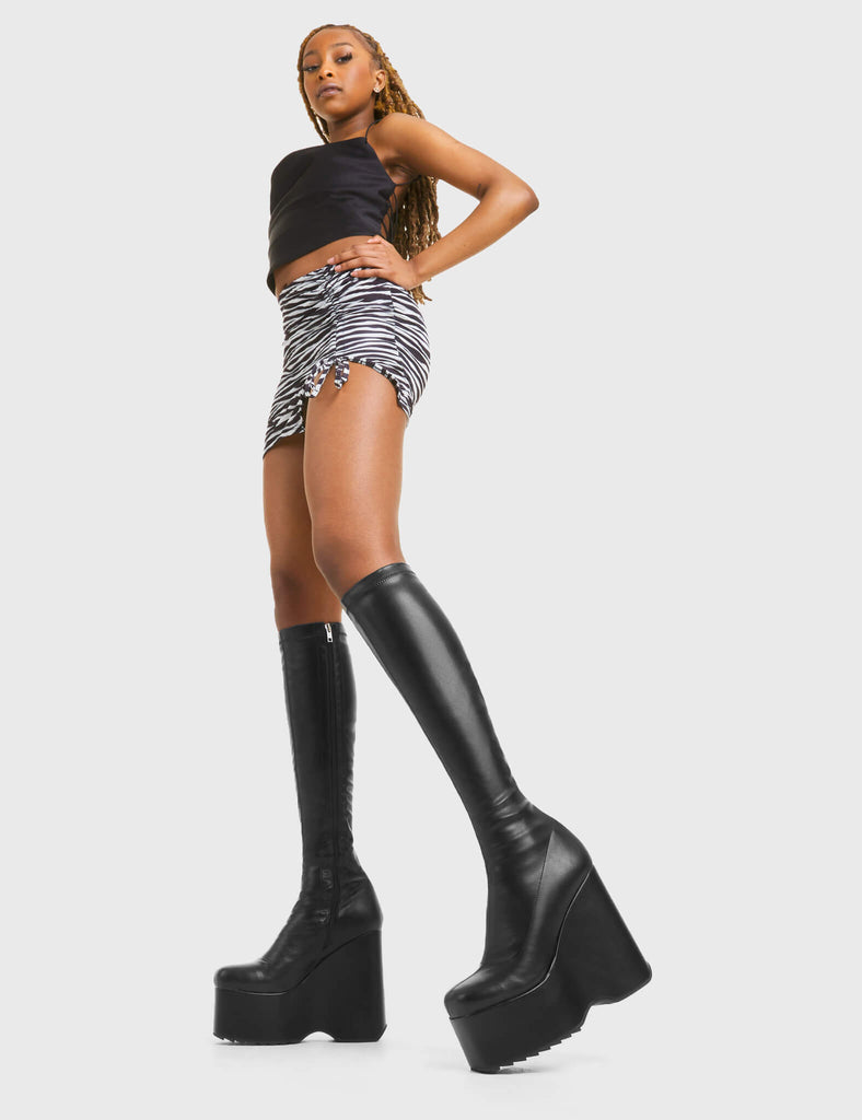 BOOTS TO DIE FOR Falling Sky Chunky Platform Knee High Boots in Black fitted faux leather. These platform boots feature a minimalist look with a platformed wedge. Made with eco-friendly materials and 100% cruelty-free, these platform boots are as ethical as they are chic. - Platform Height - Knee high length - Fitted feel - Rounded toe - High Heel - 100% vegan SKU: LMF 3542 - BlackStretchPU