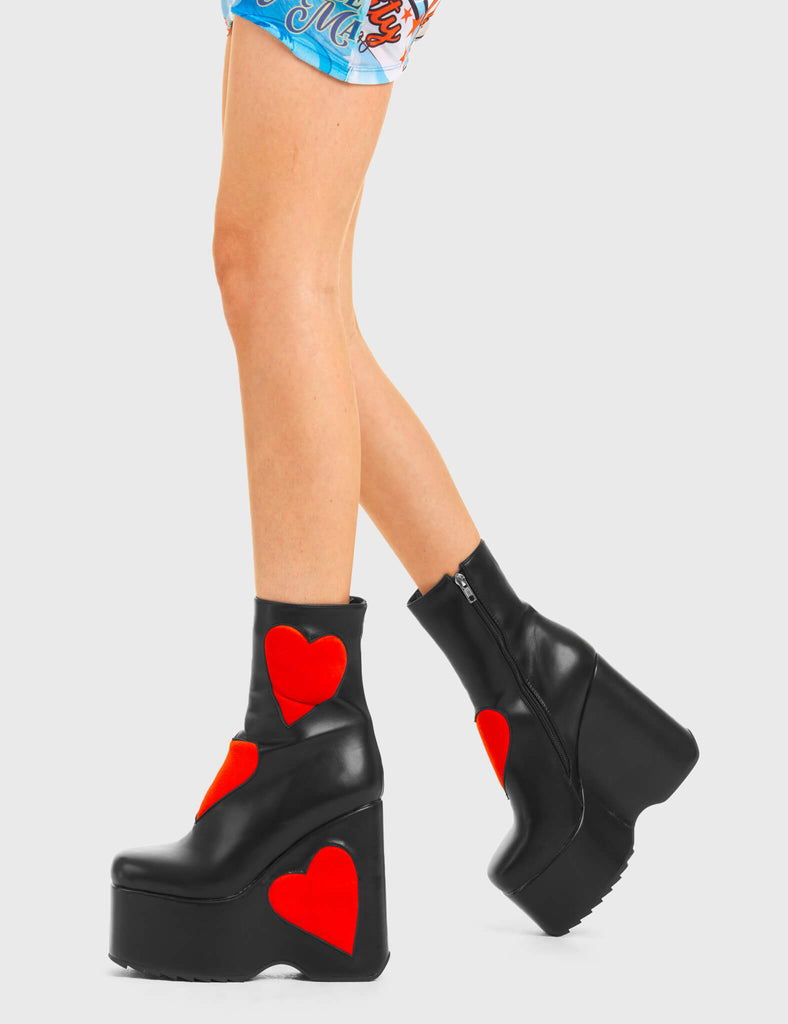 IT'S ALL ABOUT LOVE Full Time Lover Chunky Platform Ankle Boots in Black faux leather. These platform boots feature big red hearts with a platformed wedge. Made with eco-friendly materials and 100% cruelty-free, these platform boots are as ethical as they are chic. - Platform Height - Ankle length - Red hearts - Rounded toe - High Heel - 100% vegan SKU: LMF 3538 - BlackPU/RedHeart