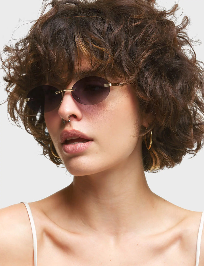 Game Oval Sunglasses. These Oval sunglasses feature antique style Gold arms, and a Dark Purple / Black tinted lens.