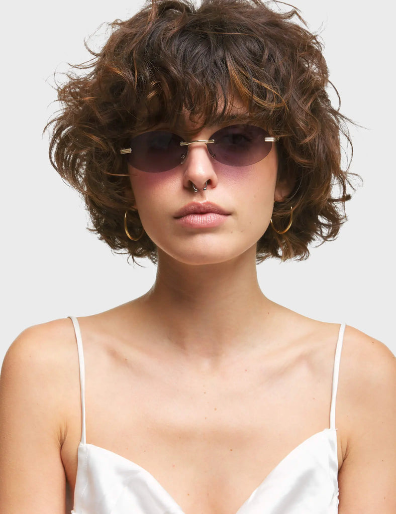 Game Oval Sunglasses. These Oval sunglasses feature antique style Gold arms, and a Dark Purple / Black tinted lens.