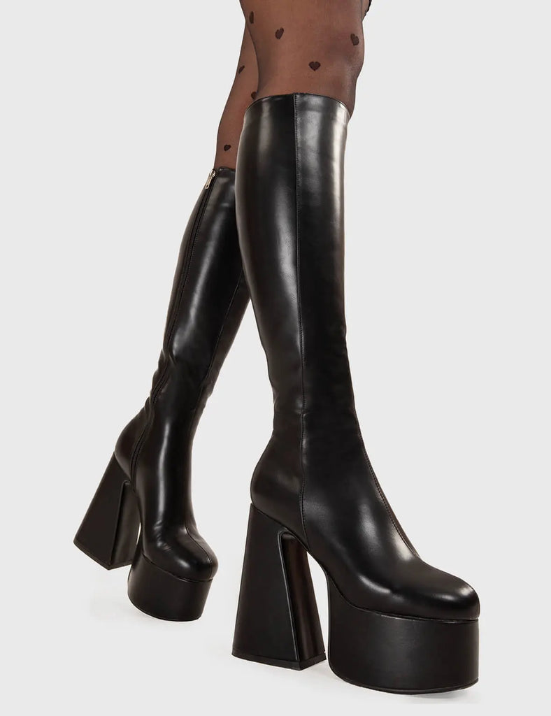NICE AND SMOOTH Hate You Platform Knee High Boots in Black faux leather. These platform boots feature a minimalist look with a Flared heel, keeping it nice and classy. Made with eco-friendly materials and 100% cruelty-free, these platform boots are as ethical as they are chic. - Platform Height - Knee high - Flared heel - High Heel - 100% vegan SKU: LMF 3355 - BlackPU