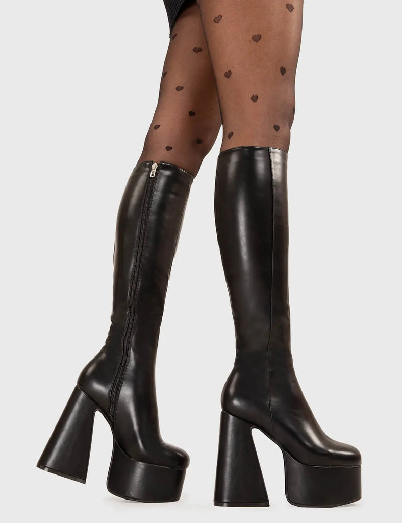 NICE AND SMOOTH Hate You Platform Knee High Boots in Black faux leather. These platform boots feature a minimalist look with a Flared heel, keeping it nice and classy. Made with eco-friendly materials and 100% cruelty-free, these platform boots are as ethical as they are chic. - Platform Height - Knee high - Flared heel - High Heel - 100% vegan SKU: LMF 3355 - BlackPU