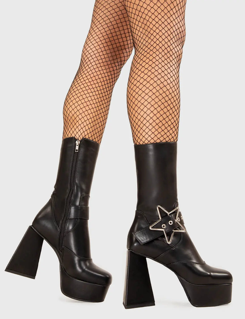 STAR IN THE SKY Hound Dog Platform Ankle Boots in Black faux leather. These platform boots feature a sliver star buckle with an adjustable strap, keeping it nice and edgy. Made with eco-friendly materials and 100% cruelty-free, these platform boots are as ethical as they are chic. - Platform Height - Silver Star buckles - Calf length - Adjustable straps - Triangle heel - High Heel - 100% vegan SKU: LMF 3336 - BlackPU