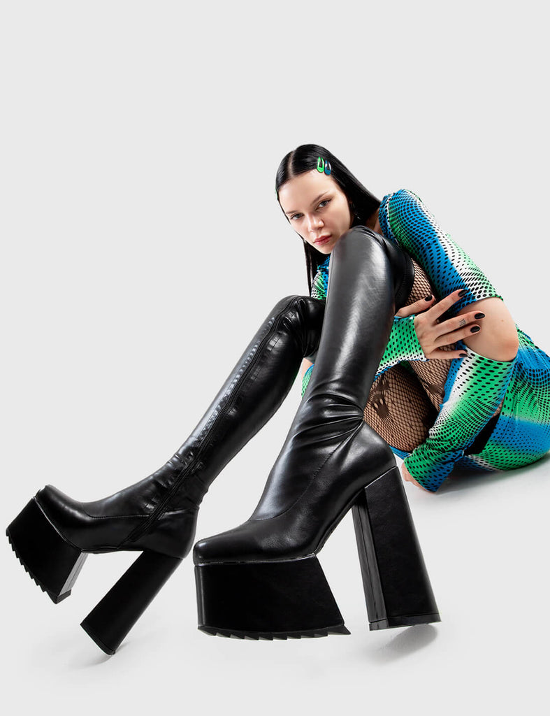 Not Your Basic Boots Late Night Vibes Platform Thigh High Boots Boots in Black faux leather. These platform boots feature a minimalist design, with a fitted feel, the perfect pair with any outfit. Made with eco-friendly materials and 100% cruelty-free, these platform boots are as ethical as they are Cool! - Platform Height - Heel Height - Black Zipper - Fitted feel - Thigh length - Platform sole - Shark's teeth grip - High Heel - 100% vegan SKU: LMF 2878 - BlackPU