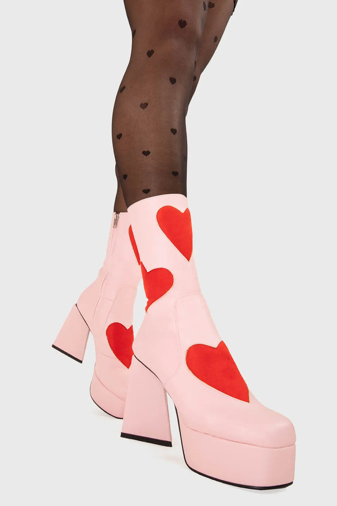 LOVEY DOVEY Letter To My Lover Platform Ankle Boots in Pink faux leather. These platform boots feature a pink boot with big red heart all over. Made with eco-friendly materials and 100% cruelty-free, these platform boots are as ethical as they are chic. - Platform Height - Big red hearts - Calf length - Triangle heel - High Heel - 100% vegan SKU: LMF 3337 - PinkPU/RedHeart