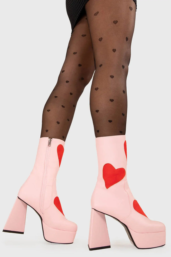 LOVEY DOVEY Letter To My Lover Platform Ankle Boots in Pink faux leather. These platform boots feature a pink boot with big red heart all over. Made with eco-friendly materials and 100% cruelty-free, these platform boots are as ethical as they are chic. - Platform Height - Big red hearts - Calf length - Triangle heel - High Heel - 100% vegan SKU: LMF 3337 - PinkPU/RedHeart