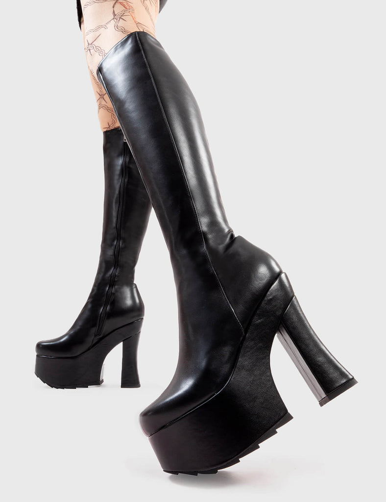 Not Your Basic Boots Night Vision Platform Knee High Boots in Black faux leather. These platform boots feature a minimalist design withj a curved heel, the perfect way to elevate any look. Made with eco-friendly materials and 100% cruelty-free, these platform boots are as ethical as they are cool. - Platform Height - Heel Height - Curved Heel - Black Zip - Shark's teeth grip - Chunky Platform sole - 100% vegan SKU: LMF 2926 - BlackPU