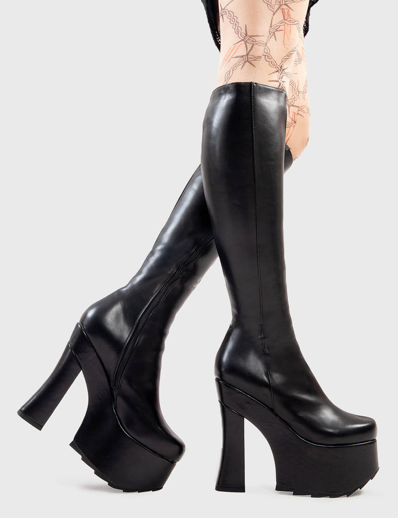 Not Your Basic Boots Night Vision Platform Knee High Boots in Black faux leather. These platform boots feature a minimalist design withj a curved heel, the perfect way to elevate any look. Made with eco-friendly materials and 100% cruelty-free, these platform boots are as ethical as they are cool. - Platform Height - Heel Height - Curved Heel - Black Zip - Shark's teeth grip - Chunky Platform sole - 100% vegan SKU: LMF 2926 - BlackPU