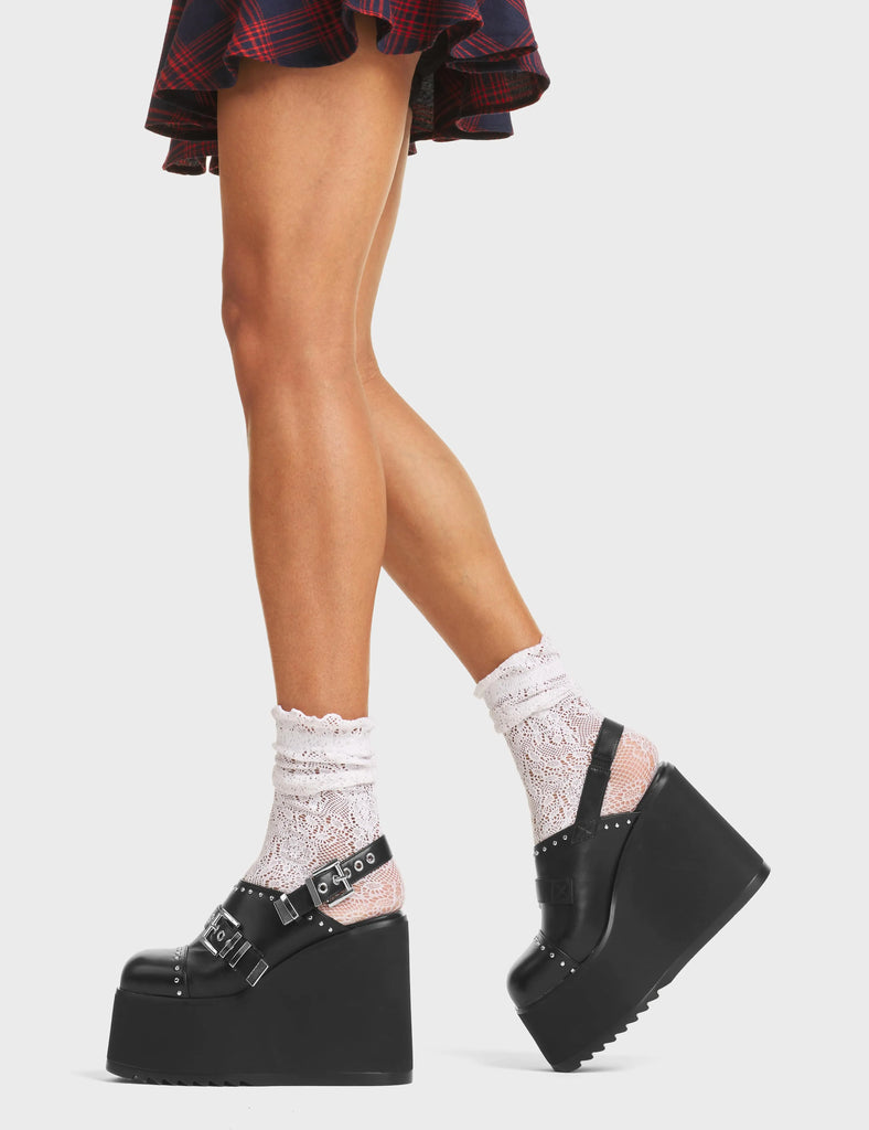 No Shadow Chunky Platform Shoes in Black faux leather. These platform shoes feature a sling-back design, two adjustable straps with square-shaped buckles and silver eyelets, and silver stud detailing. Made with eco-friendly materials and 100% cruelty-free! 