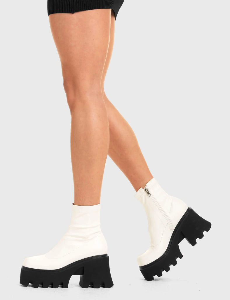 UPGRADE YOUR STYLE Notorious Chunky Platform Ankle Boots in White fitted faux leather. These vegan western Boots feature a minimalist look with chunky soles, very classy. Made with eco-friendly materials and 100% cruelty-free, these boots are as ethical as they are edgy! - Chunky Platform - Ankle length - Rounded toe - 100% vegan SKU: LMF 3601 - WhiteStretchPU