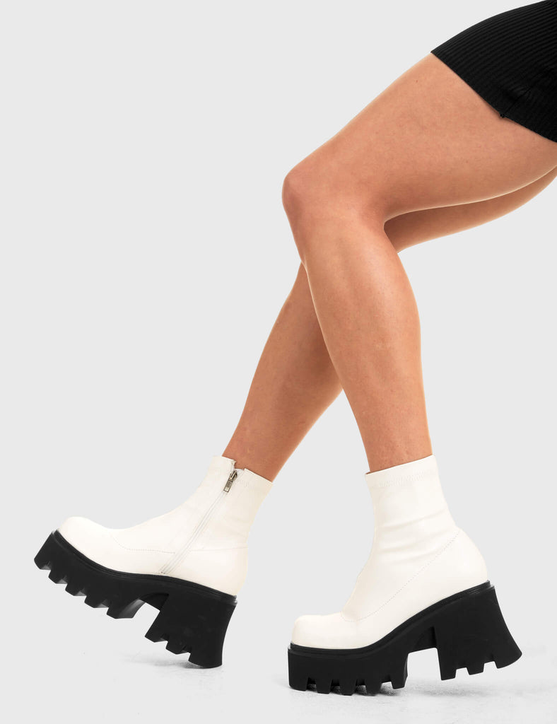 UPGRADE YOUR STYLE Notorious Chunky Platform Ankle Boots in White fitted faux leather. These vegan western Boots feature a minimalist look with chunky soles, very classy. Made with eco-friendly materials and 100% cruelty-free, these boots are as ethical as they are edgy! - Chunky Platform - Ankle length - Rounded toe - 100% vegan SKU: LMF 3601 - WhiteStretchPU