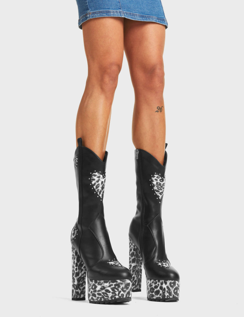 Rejector Platform Calf Boots in Black. These boots feature leopard suede hearts with silver studs surrounding them on a shark-toothed platform sole. Made with eco-friendly materials and 100% cruelty-free.