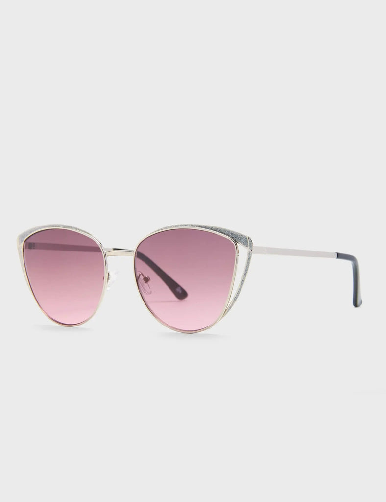 Rosa Cateye Sunglasses. These Cateye sunglasses feature a Silver frame with Silver Glitter eyebrows, and a dark Pink tinted lens.