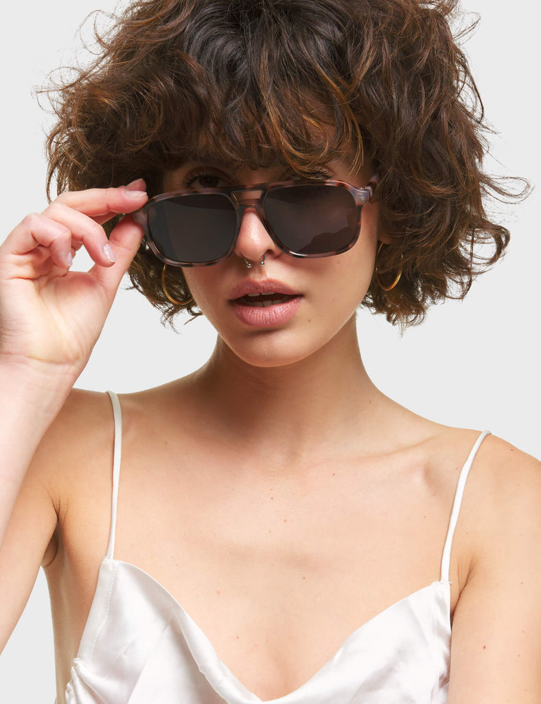 Shelly Aviator Sunglasses. These Aviator sunglasses feature a Brown Leopard print frame, and a Dark Purple / Black tinted lens.
