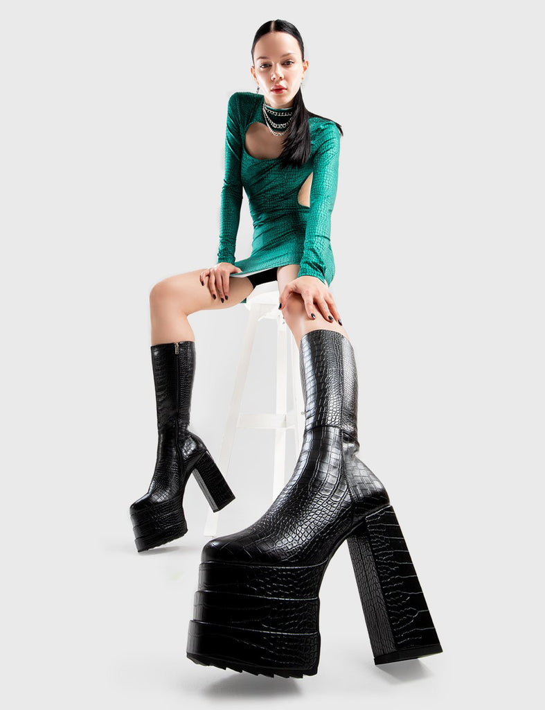 Eye-catching beauties! Step On You Platform Calf Boots in Black faux crocodile leather. These platform boots feature a minimalist design on our triple stack platform sole. Made with eco-friendly materials and 100% cruelty-free, these platform boots are as ethical as they are fierce. - Platform Height - Heel Height - Black zip - Croc print - High Heel - Triple Stack platform sole - 100% vegan SKU: LMF 2999 - BlackCROC