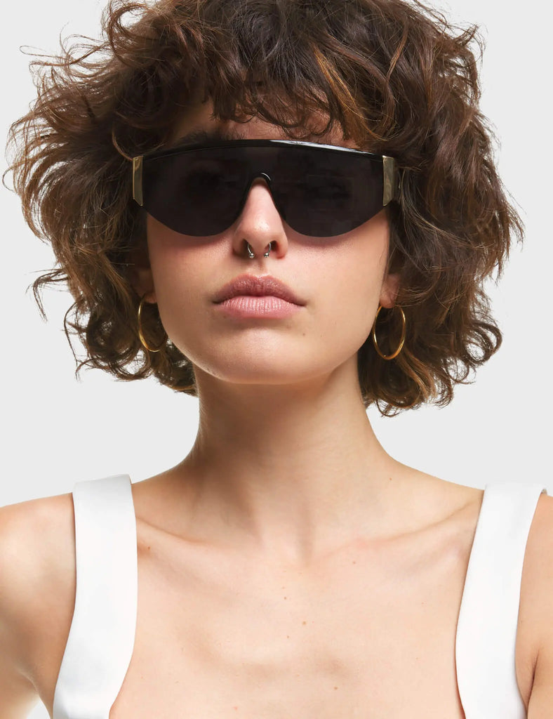 Throw Shade Visor Sunglasses. These Visor sunglasses feature Gold touches on the frame, and a Black tinted lens.