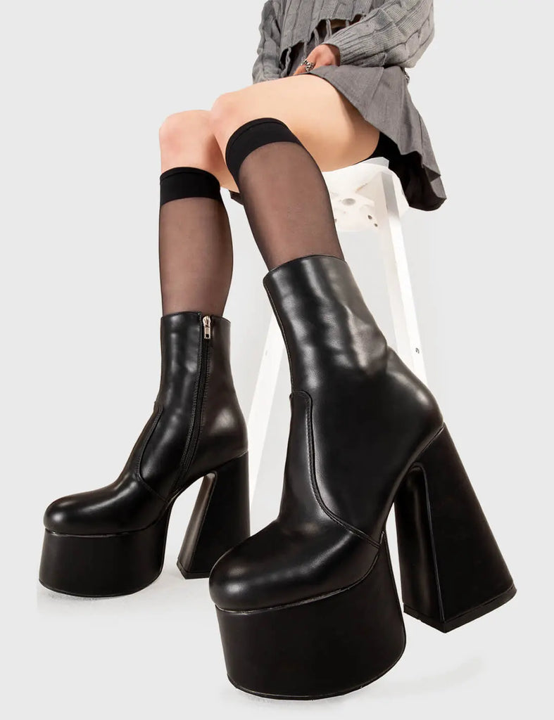 NOT YOUR AVERAGE BOOT Under Cover Platform Ankle Boots in Black faux leather. These platform boots feature a minimalist look with a flared heel, keeping it nice and classy. Made with eco-friendly materials and 100% cruelty-free, these platform boots are as ethical as they are chic. - Platform Height - Ankle length - Flared heel - High Heel - 100% vegan SKU: LMF 3349 - BlackPU