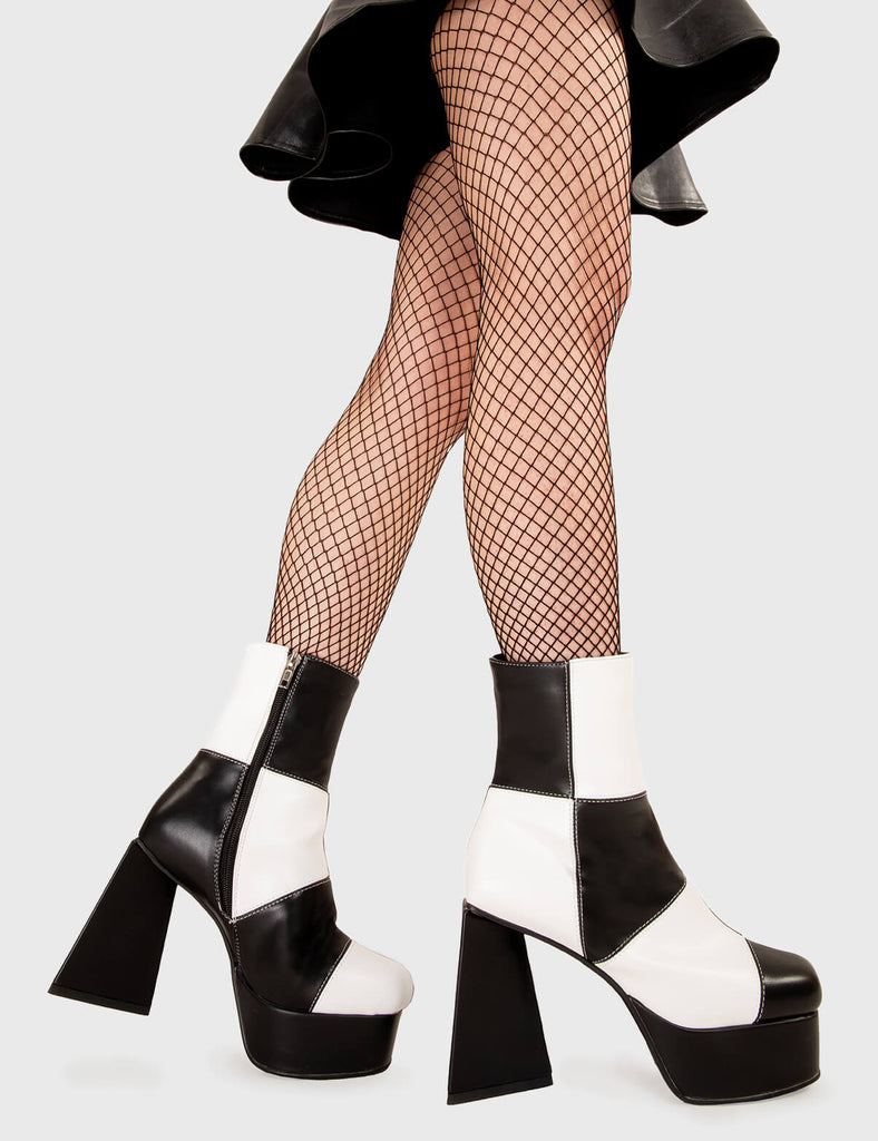 TIME TO DANCE Wait A Minute Platform Ankle Boots in Black and white faux leather. These platform boots feature a black and white patch work design with a triangle heel, keeping it nice and classy. Made with eco-friendly materials and 100% cruelty-free, these platform boots are as ethical as they are chic. - Platform Height - Ankle length - Patch work design - Triangle heel - High Heel - 100% vegan SKU: LMF 3330 - BlackPU/WhitePU