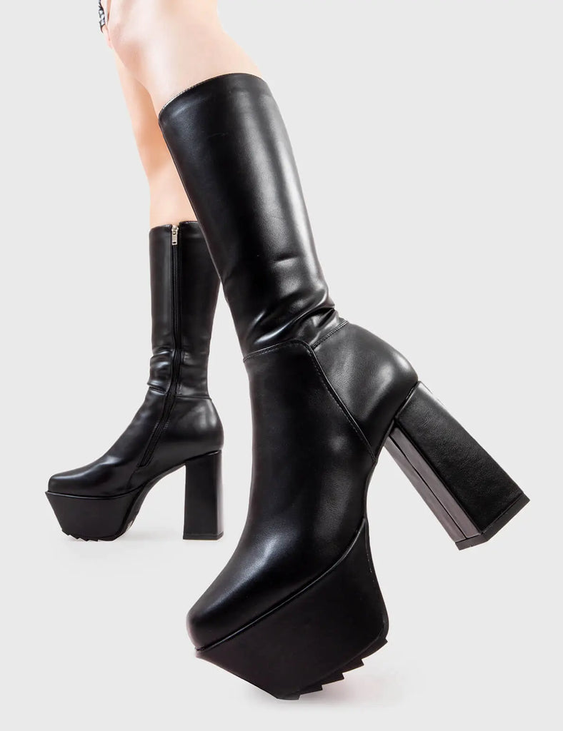 Next Level Who Cares Platform Calf Boots in Black faux leather. These platform boots feature on a chunky platform sole, leave them with a lasting impression.Made with eco-friendly materials and 100% cruelty-free, these platform boots are as ethical as they are Next Level. - Platform Height - Heel Height - Black Zipper - Calf length - Chunky Platform sole - Shark's teeth grip - Square Toe - 100% vegan SKU: LMF 2824 - BlackPU