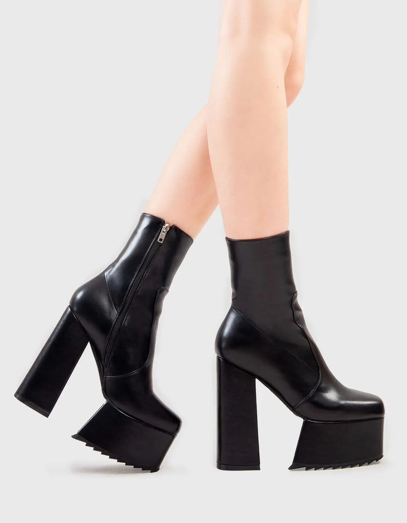 Not Your Basic Boots Wrath Platform Ankle Boots in Black faux leather. These platform boots feature a minimalist design, with stitch detailing, the perfect pair with any outfit. Made with eco-friendly materials and 100% cruelty-free, these platform boots are as ethical as they are Cool! - Platform Height - Heel Height - Black Zipper - Ankle length - Platform sole - Shark's teeth grip - High Heel - 100% vegan SKU: LMF 2859 - BlackPU