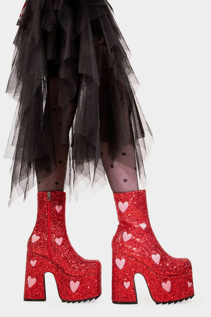 Fairy Dust
 
 Keeper Chunky Platform Ankle Creeper Boot in Red Glitter. These red vegan Platform Boots feature our iconic glitter detail throughout with pink suede hearts, leave a trail of sparkle and make every step a dazzling statment Made with eco-friendly materials and 100% cruelty-free.
 
 
 - Platform Height
 - Heel Height 
 - Red zipper 
 - Pink suede hearts 
 - Chunky Creeper sole
 - Shark's teeth grip
 - Round Toe
 - 100% vegan 
 
 SKU: LMF 2047 - RedGlitter/PinkHeart