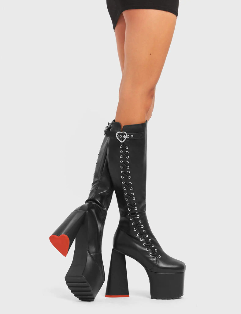 INTRINSIC LOVE

Passion Platform Knee High Boots in Black faux leather. These platform boots feature a stylish look with a heart shaped heel with a red heart at the bottom. These boots also feature lace up detail across the entire side of the boots. Also features a strap that includes a heart buckle and silver eyelets Made with 100% vegan.materials.

- Platform Height
- Knee length
- Heart shaped heel
- Red Heart Detail
- Lace Up Detail
- Black Zip
- High Heel
- 100% vegan

SKU: LMF 4908 - BlackPU