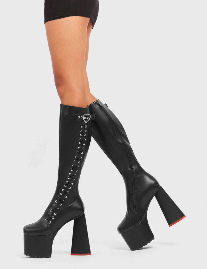 INTRINSIC LOVE

Passion Platform Knee High Boots in Black faux leather. These platform boots feature a stylish look with a heart shaped heel with a red heart at the bottom. These boots also feature lace up detail across the entire side of the boots. Also features a strap that includes a heart buckle and silver eyelets Made with 100% vegan.materials.

- Platform Height
- Knee length
- Heart shaped heel
- Red Heart Detail
- Lace Up Detail
- Black Zip
- High Heel
- 100% vegan

SKU: LMF 4908 - BlackPU