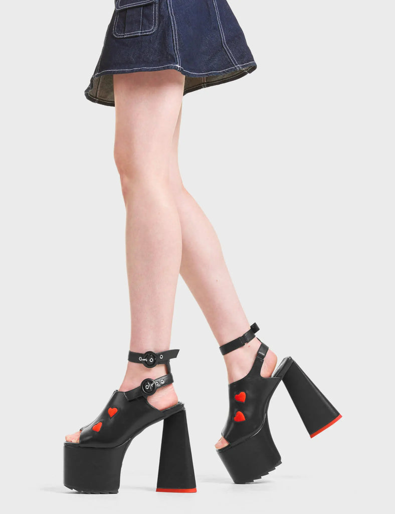 TWISTED LOVE

Perfect Girl Platform Sandals in Black faux leather. These platform sandals features two hearts on the upper and adjustable straps with silver eyelets and black 'O' ring shaped buckles. Also features a heart shaped heel with a red heart on the bottom. Made with eco-friendly materials and 100% Vegan.

- Platform Height: 5.5 CM
- Heel Height: 14 CM 
- Adjustable Straps
- 'O' ring shaped buckle
- Silver Eyelets
- Heart Heel
- Red Heart
- Open Toe
- 100% Vegan

SKU: LMF 4700 - BlackPU/RedPU
