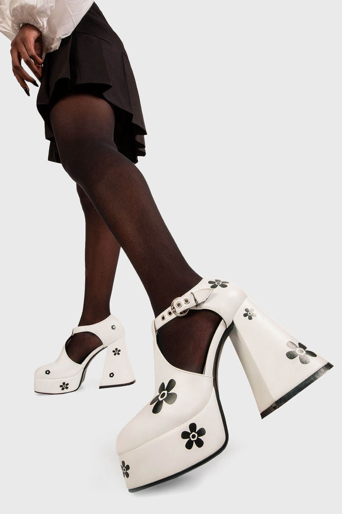 Flower Power 
 
 Please Don't Go Platform Heels in White faux leather. These vegan Platform Heels feature Black Flower print thoughout with a white adjustable strap and silver eyelets in T Bar structure, bloom with confidence in every step. 
 
 - Platform Height: 2.6 inch
 - Heel Height: 5.5 inch
 - T Bar structure
 - "O" ring shaped buckles and silver eyelets
 - Black flower print throughout 
 - Platform sole
 - Flared heel
 - Round toe 
 - 100% vegan
 
 SKU: LMF 1700 - WhitePU/BlackFlower